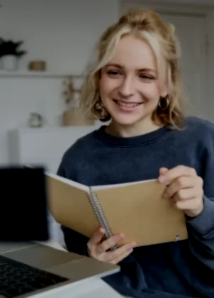 Student reviewing notes beside a laptop