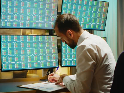 Trader reviewing market screens at a desk