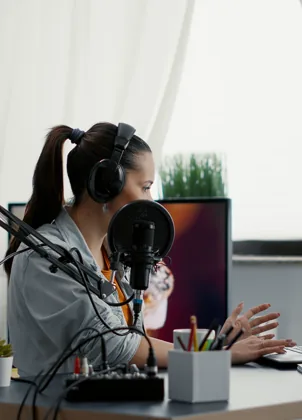 Creator broadcasting with a microphone, laptop and phone camera
