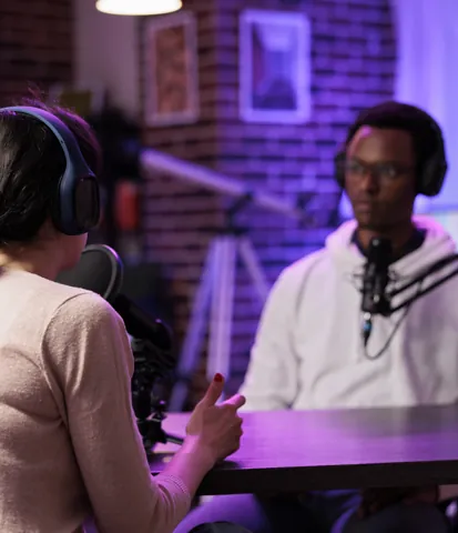 Host and guest talking in a podcast studio