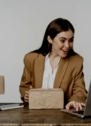 Shop owner planning a sale with a laptop and parcels