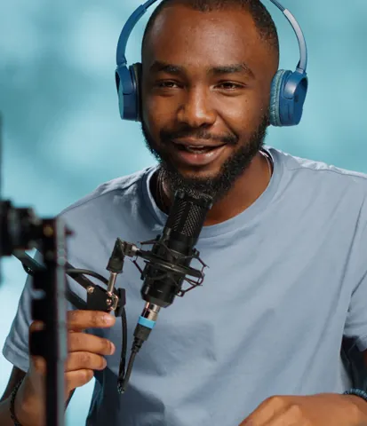 Creator recording with a smartphone beside a laptop