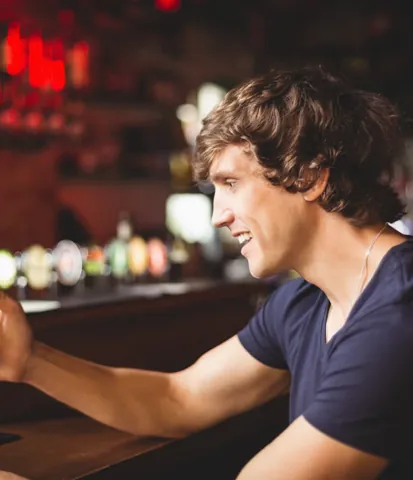 Man using a phone at a bar