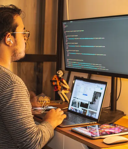 Developer comparing a website on a laptop and monitor