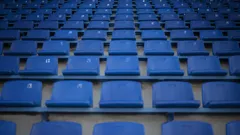 rows of empty blue seats in a stadium