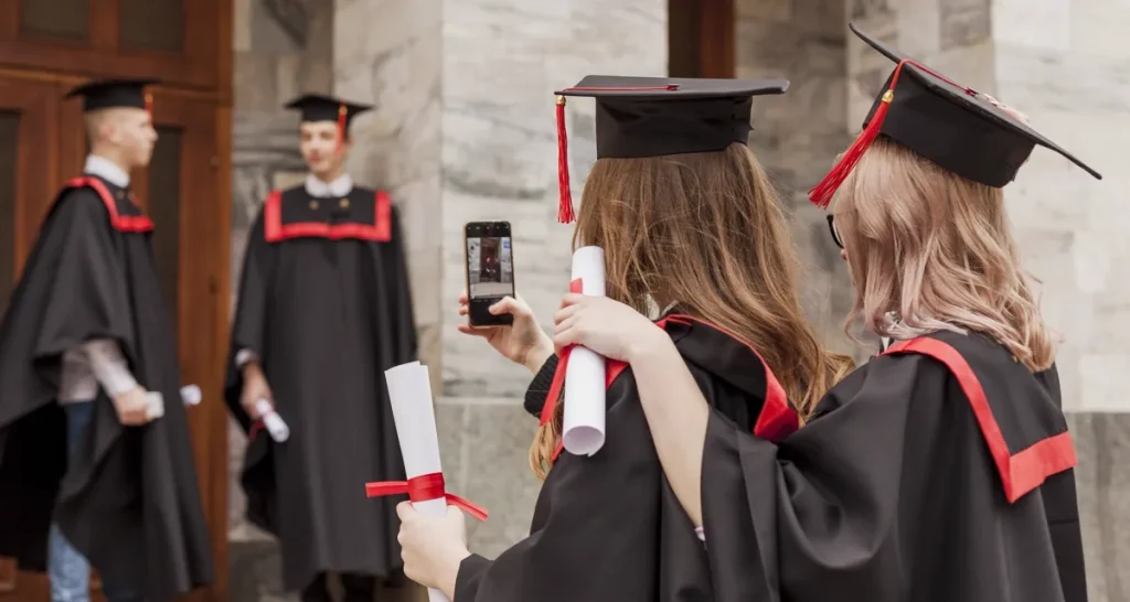 Graduates in caps and gowns recording the ceremony on a phone